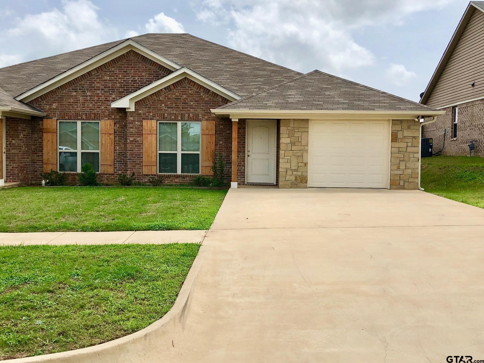 303-309 Princess Place Tyler, TX 75704 - Photo 1 of 6 a front view of a house with a garden