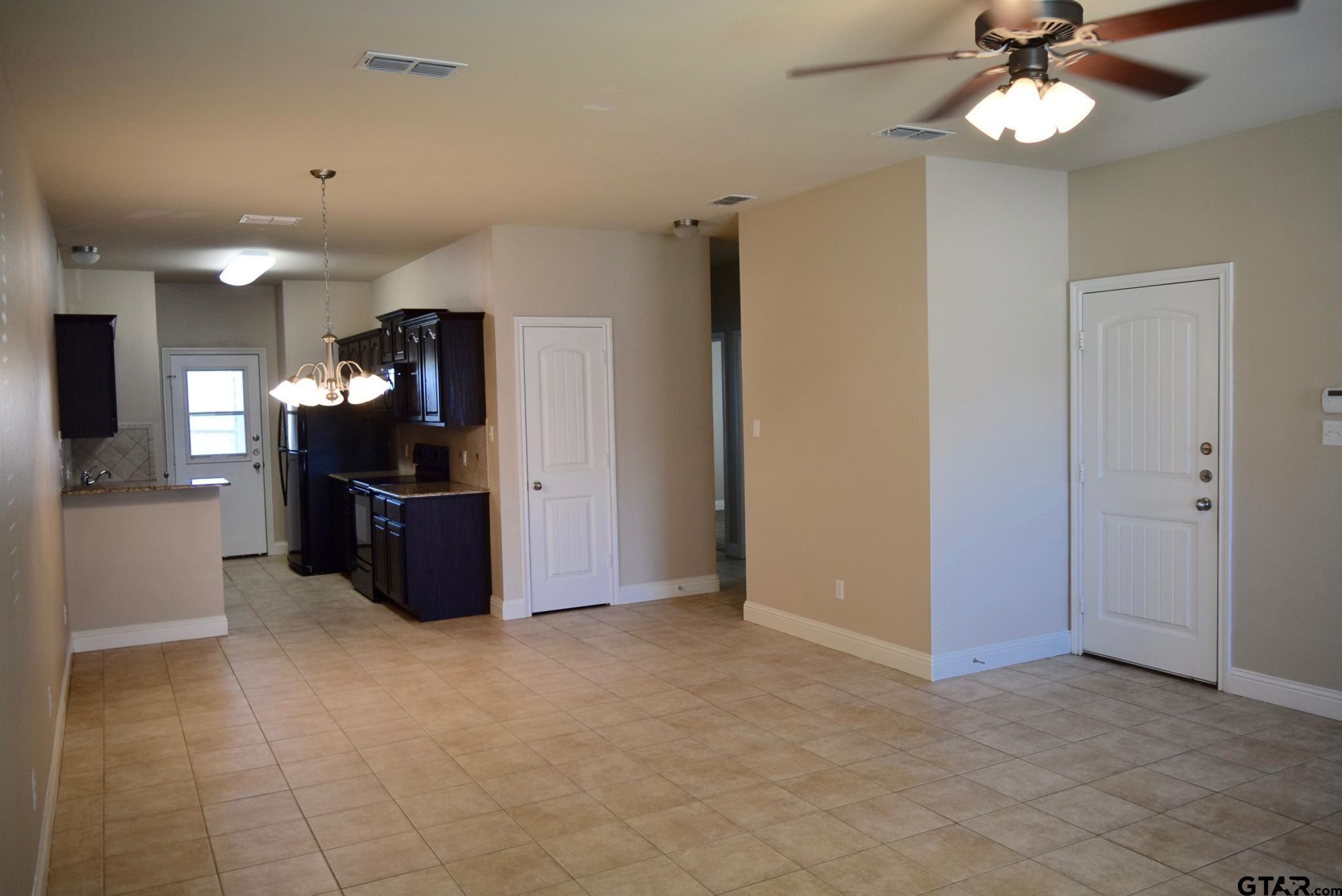 303-309 Princess Place Tyler, TX 75704 - Photo 3 of 6 a view of a kitchen with furniture and a ceiling fan