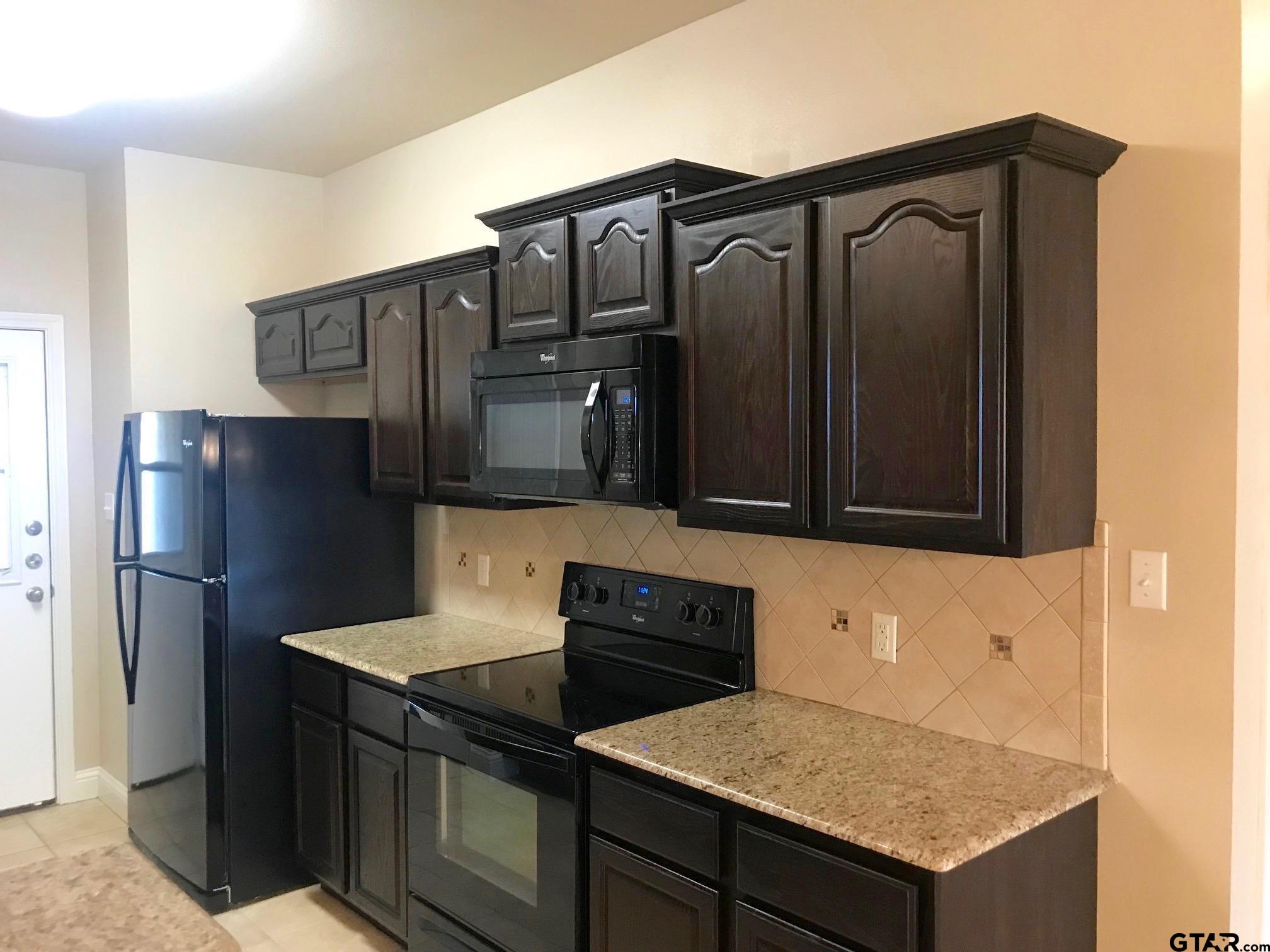 303-309 Princess Place Tyler, TX 75704 - Photo 5 of 6 a kitchen with a refrigerator and a stove top oven
