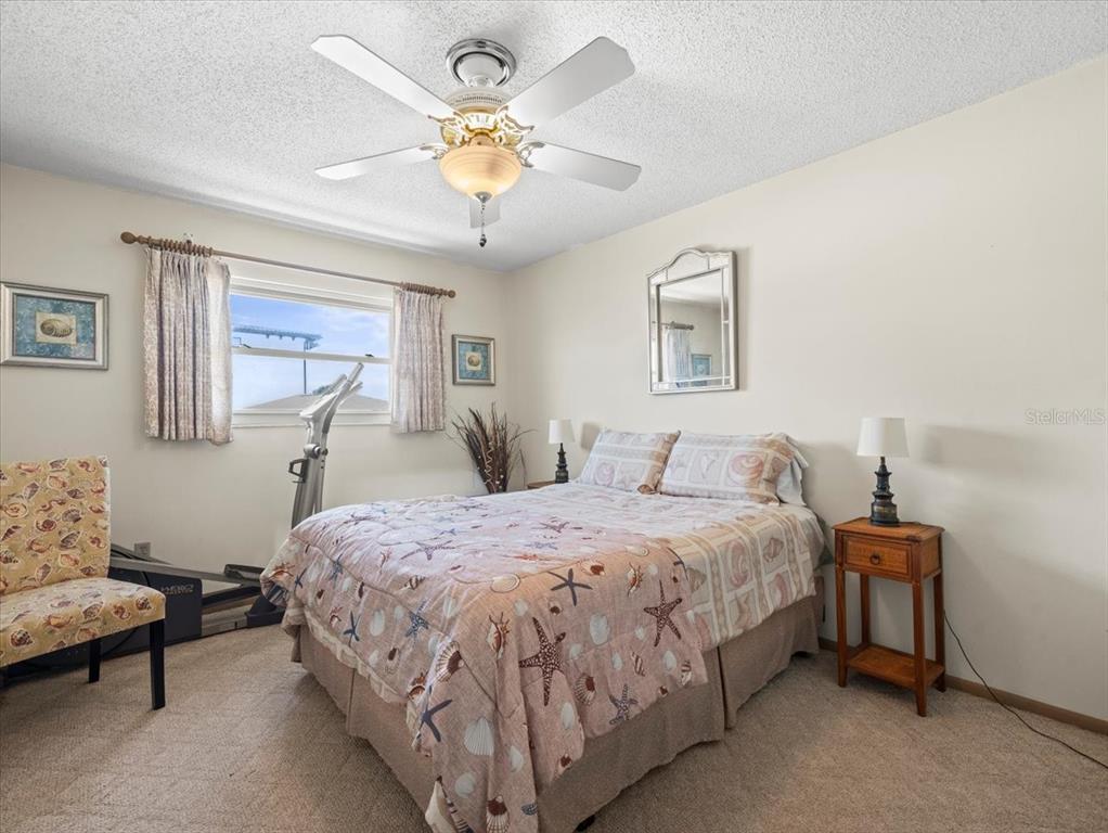 18218 Sunset Boulevard, Unit B St. Petersburg, FL 33708 - Photo 29 of 38 a bedroom with a bed and a chandelier