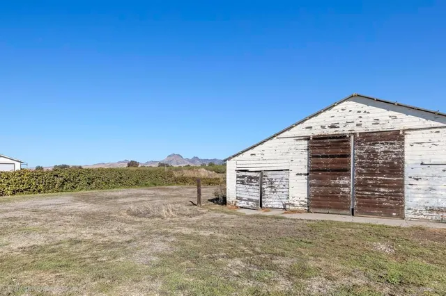 a living room with furniture floor to ceiling window hardwood floor and a flat screen tv