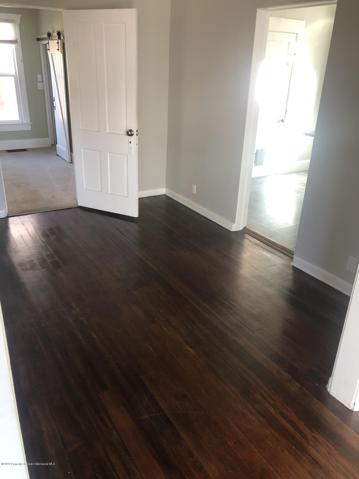 310 East 5th Street Rifle, CO 81650 - Photo 13 of 27 an empty room with wooden floor and a window