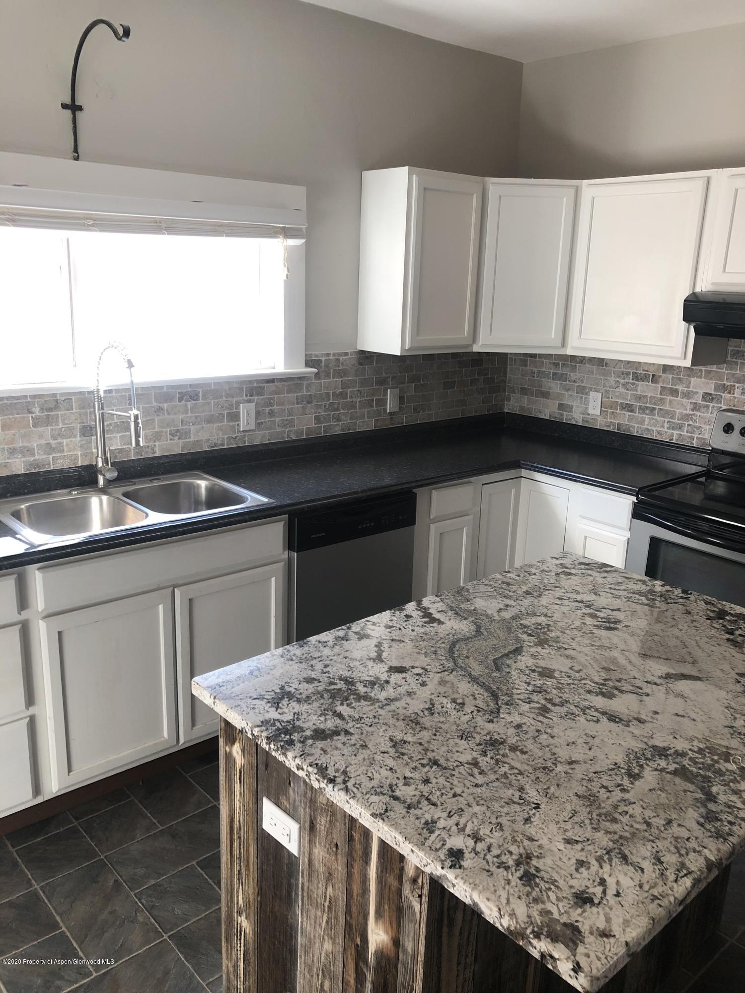 310 East 5th Street Rifle, CO 81650 - Photo 15 of 27 a kitchen with kitchen island granite countertop a sink and a stove