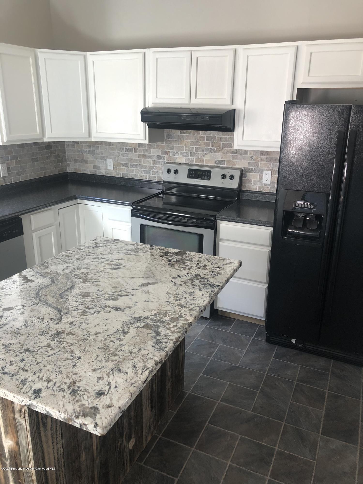 310 East 5th Street Rifle, CO 81650 - Photo 17 of 27 a kitchen with kitchen island a counter top space cabinets and stainless steel appliances