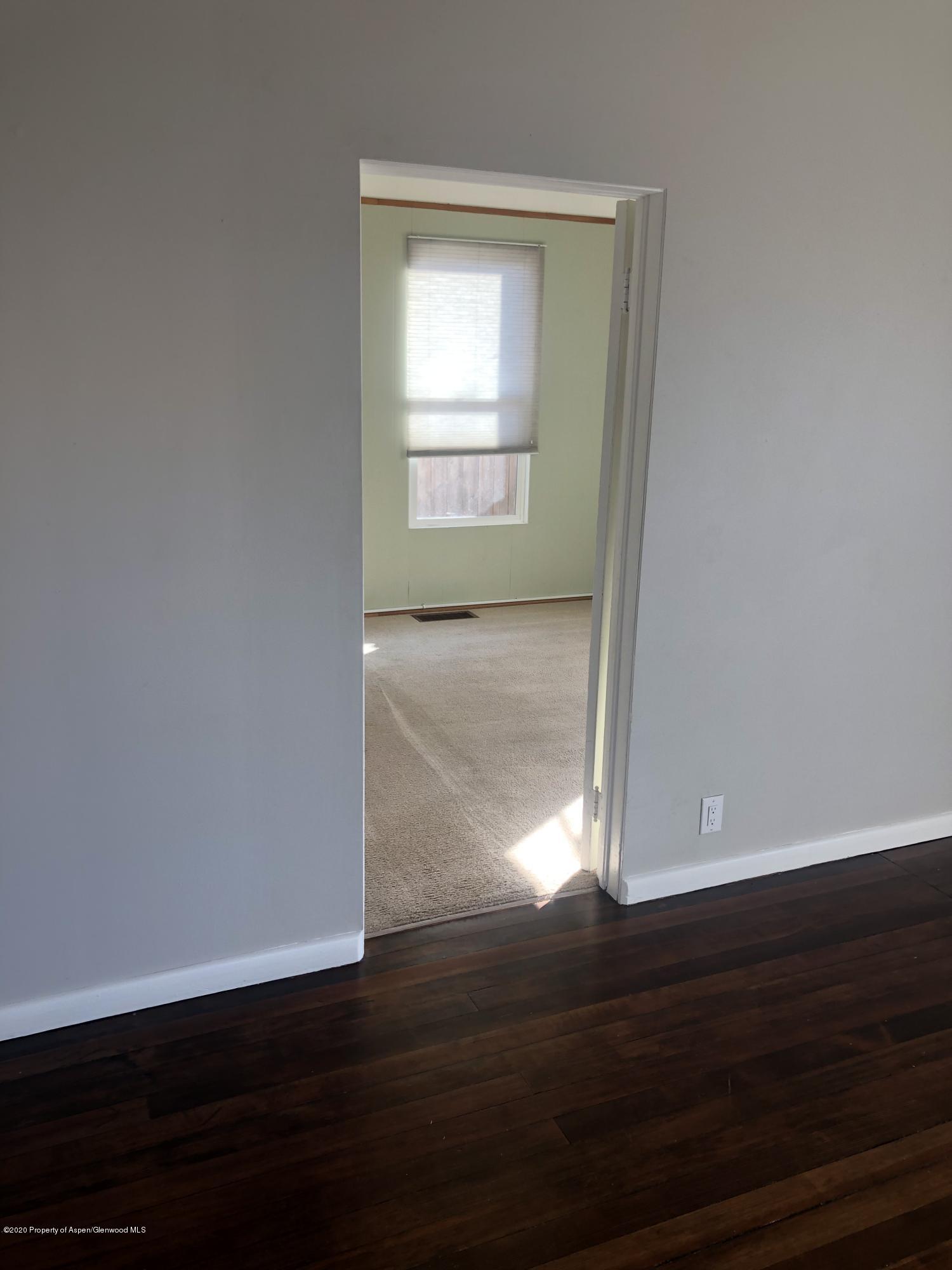 310 East 5th Street Rifle, CO 81650 - Photo 24 of 27 a view of an empty room with wooden floor and a window