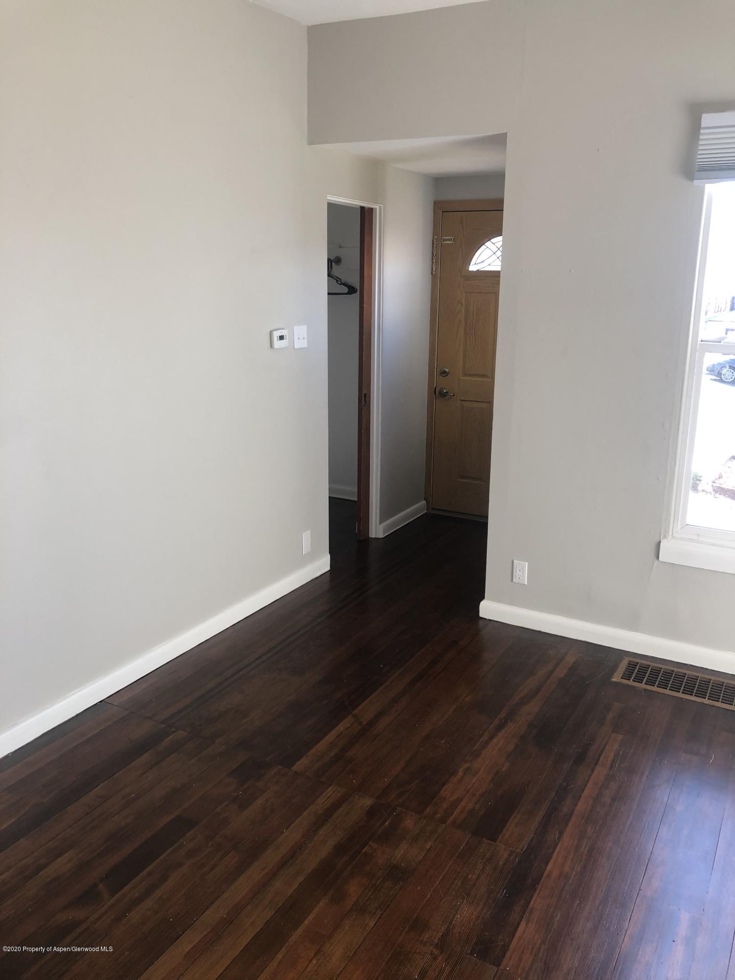 310 East 5th Street Rifle, CO 81650 - Photo 10 of 27 an empty room with wooden floor and windows