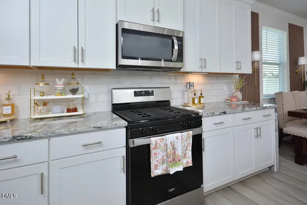 a kitchen with white cabinets and appliances