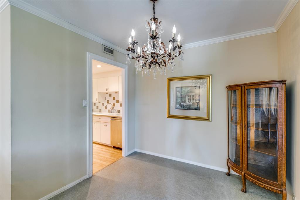 3525 Turtle Creek Boulevard, Unit 3C Dallas, TX 75219 - Photo 13 of 28 Dining area with light carpet, baseboards, visible vents, an inviting chandelier, and crown molding