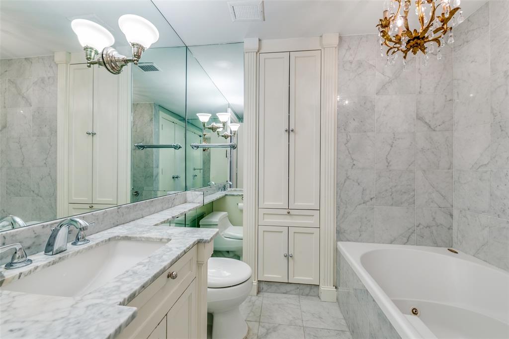 3525 Turtle Creek Boulevard, Unit 3C Dallas, TX 75219 - Photo 18 of 28 Bathroom with marble finish floor, an inviting chandelier, visible vents, and a bathing tub