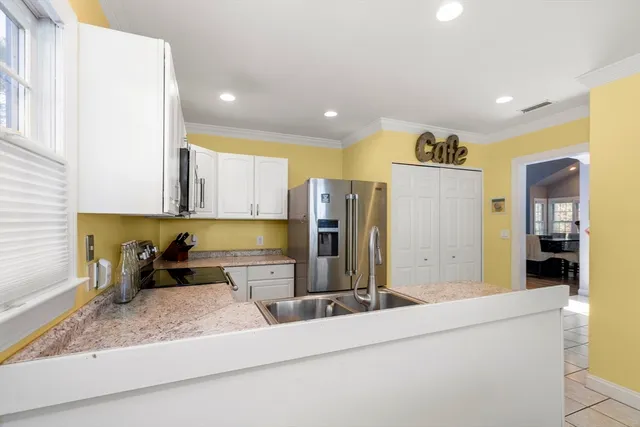 a kitchen with stainless steel appliances granite countertop a sink and a refrigerator