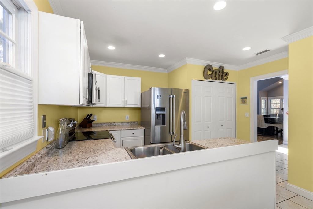 605 Middle Street, Unit 38 Braintree, MA 02184 - Photo 12 of 33 a kitchen with stainless steel appliances granite countertop a sink and a refrigerator
