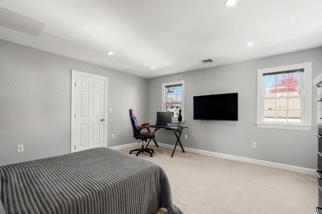 a spacious bedroom with a bed and a flat screen tv