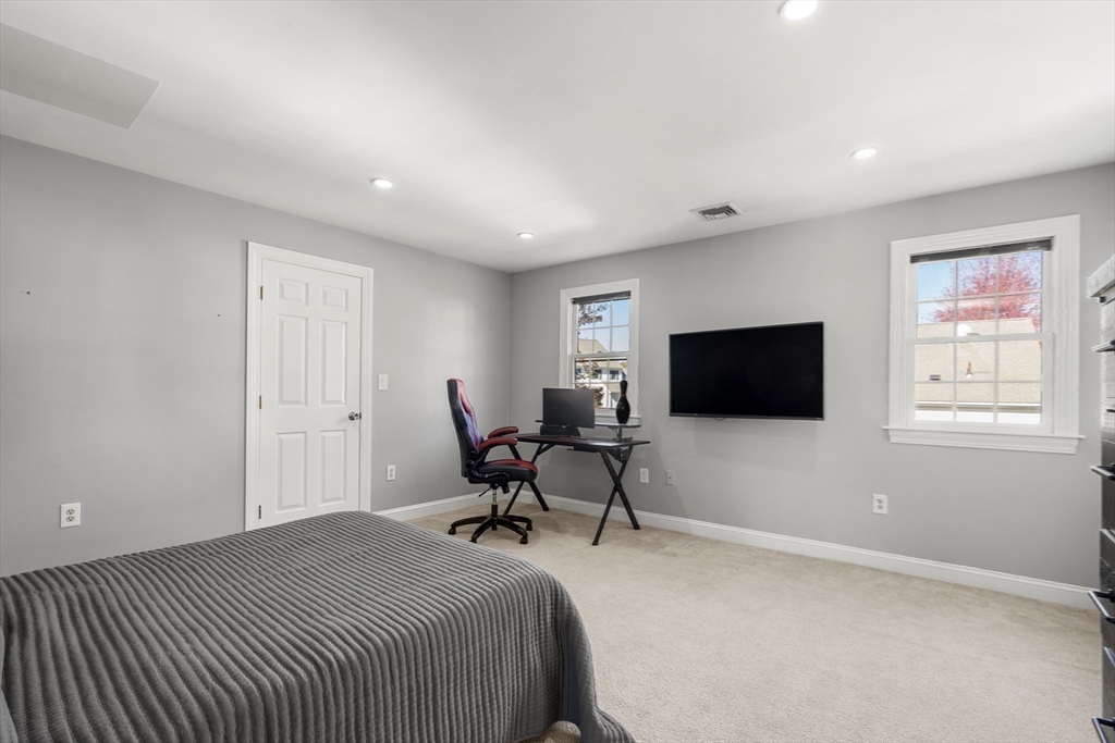 605 Middle Street, Unit 38 Braintree, MA 02184 - Photo 25 of 33 a spacious bedroom with a bed and a flat screen tv