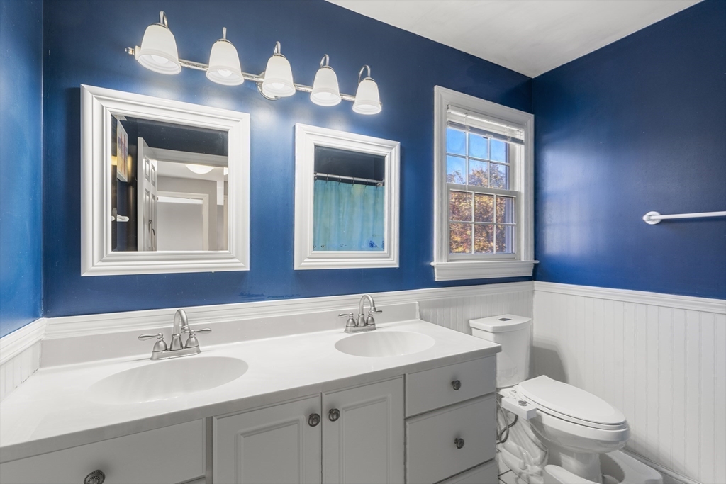 605 Middle Street, Unit 38 Braintree, MA 02184 - Photo 26 of 33 a bathroom with a toilet a sink and mirror