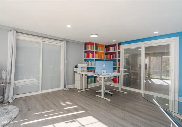 a living room with a couch and a dining table with wooden floor