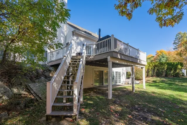 a view of a big house with a small yard and large trees