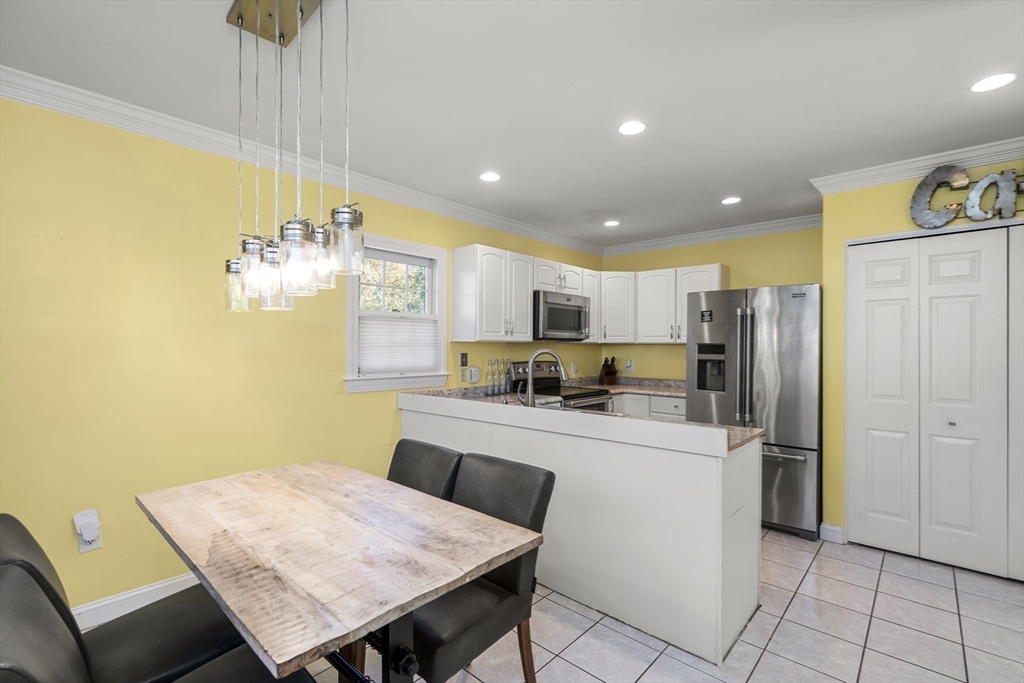 605 Middle Street, Unit 38 Braintree, MA 02184 - Photo 10 of 33 a kitchen with refrigerator and chairs