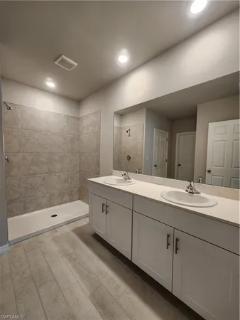 a bathroom with a double vanity sink toilet and shower