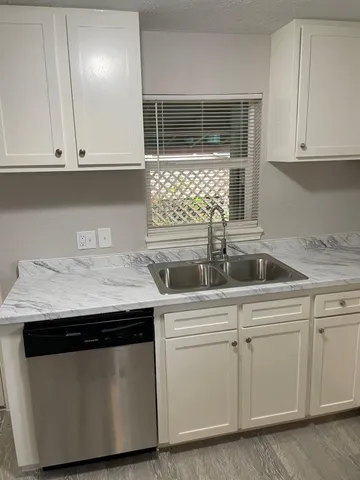 a kitchen with granite countertop white cabinets and white appliances