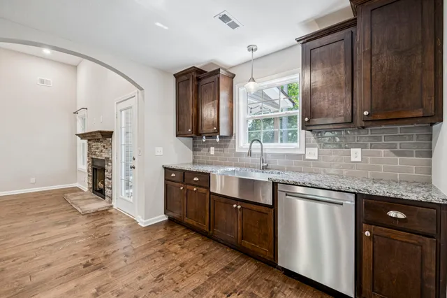 a kitchen with stainless steel appliances granite countertop wooden cabinets a sink and a granite counter tops
