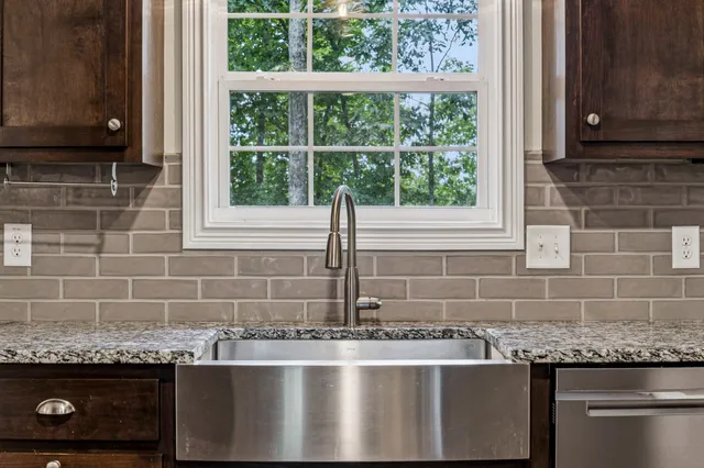 a kitchen with granite countertop a sink and a window