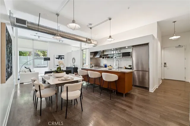 a dining room with a table chairs and a kitchen view