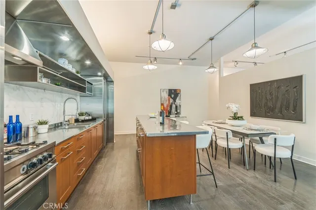 a large kitchen with kitchen island a stove a sink a dining table and chairs