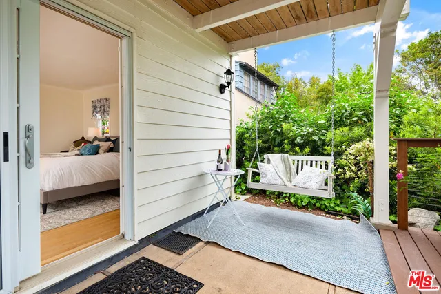 a view of a patio with a dining table and chairs with wooden floor