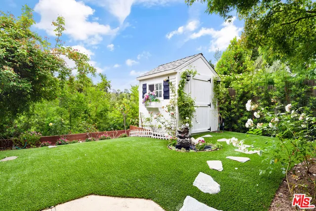 a view of a chair and table in backyard of the house