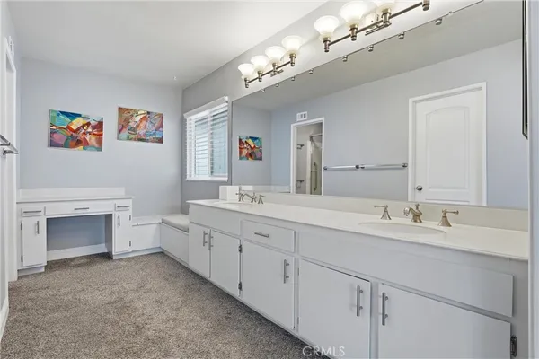 a spacious bathroom with a double vanity sink a mirror and a