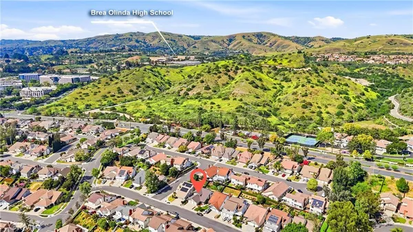 an aerial view of residential houses with outdoor space and trees