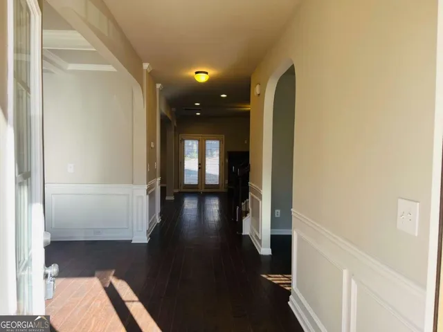 a view of hallway with livingroom and wooden floor