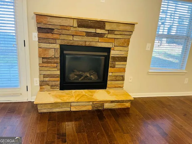 a living room with a fireplace wooden floor and a window