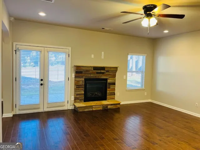 a living room with a fireplace and wooden floor