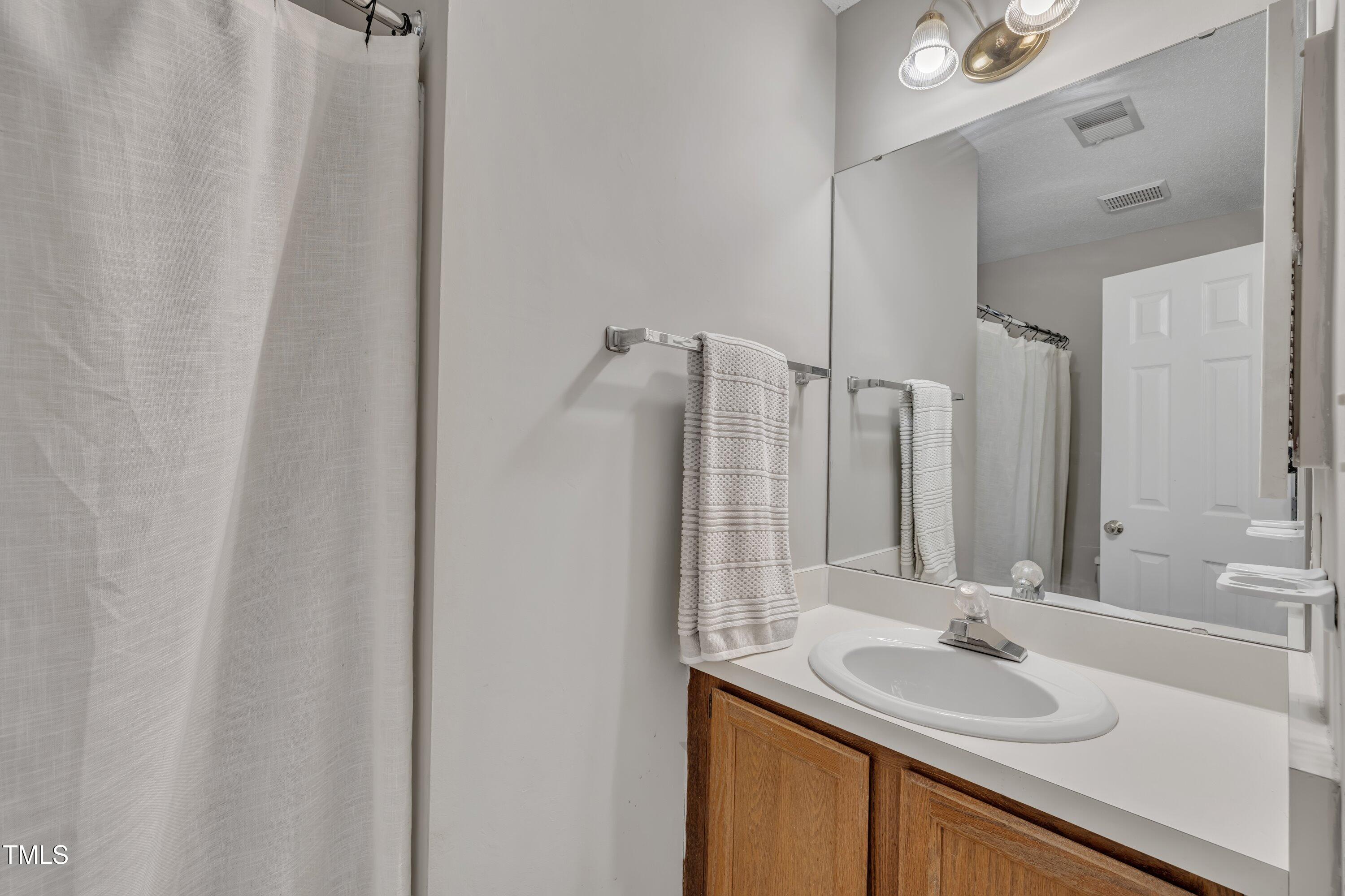 1442 Barton Pl Drive Raleigh, NC 27608 - Photo 13 of 16 a bathroom with a sink and a mirror