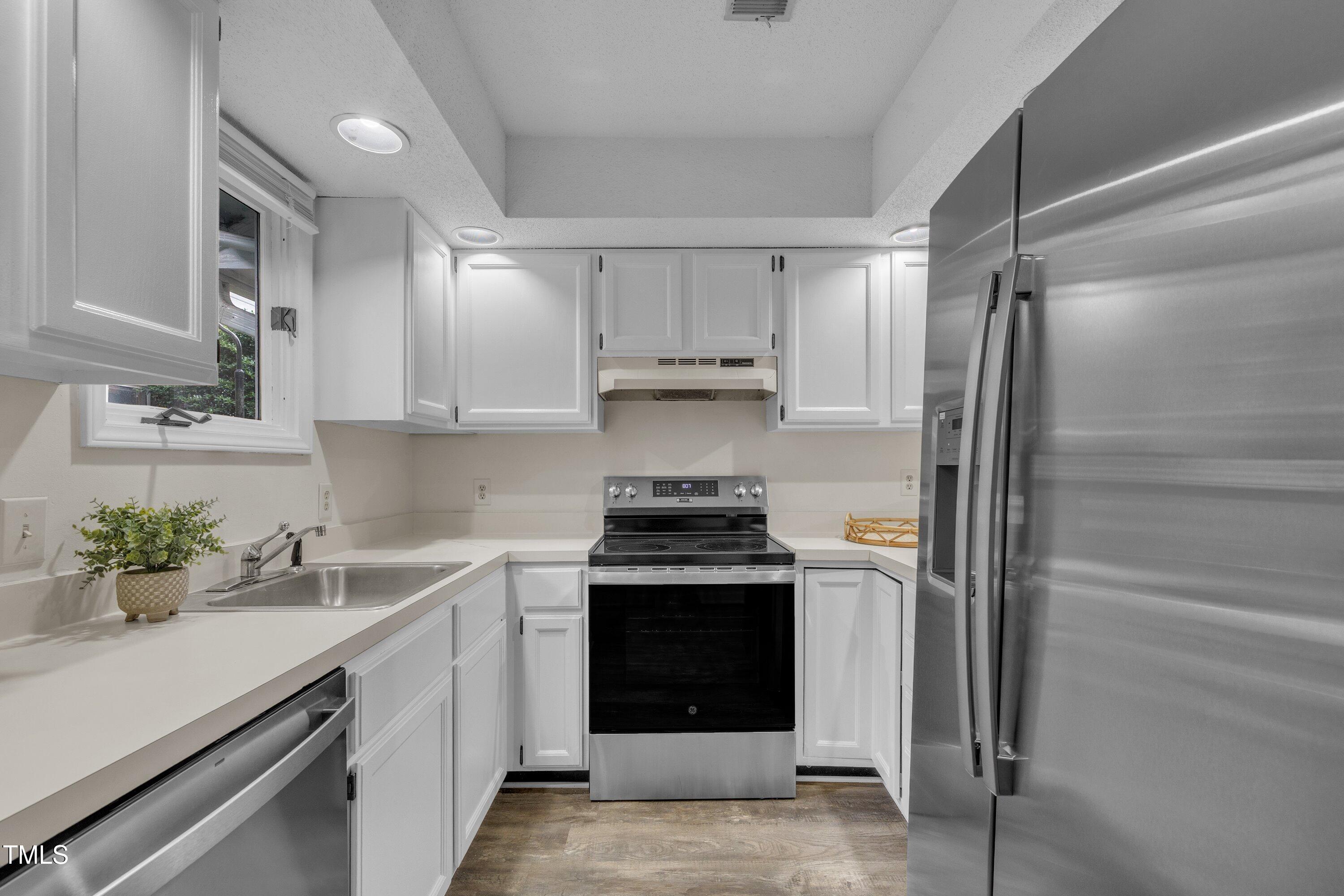 1442 Barton Pl Drive Raleigh, NC 27608 - Photo 2 of 16 a kitchen with cabinets a washer and dryer