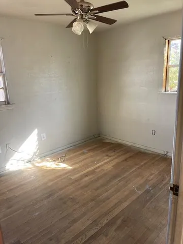 a view of a room with wooden floor and fan