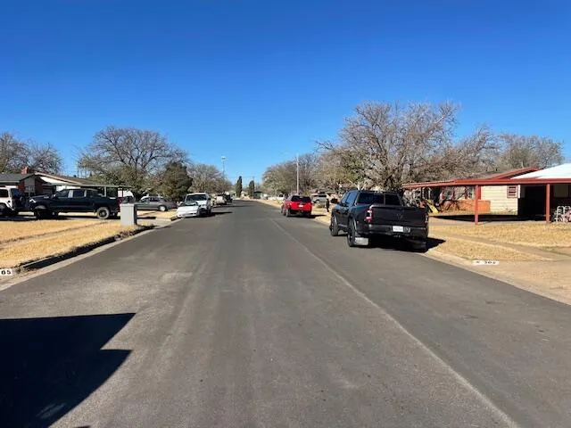 a view of a city street with a car parked on the road