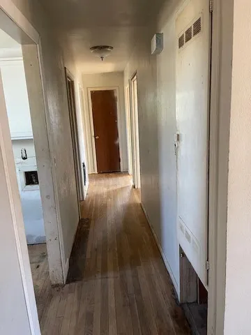 a view of a hallway with wooden floor and staircase