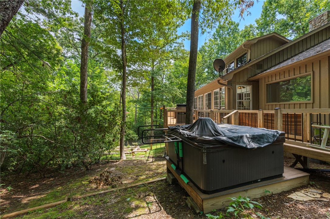 300 Whispering Falls Road Pickens, SC 29671 - Photo 27 of 41 Mature trees frame a spacious wooden deck with a private hot tub.