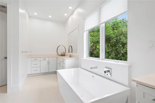 a spacious bathroom with a bathtub shower sink and mirror