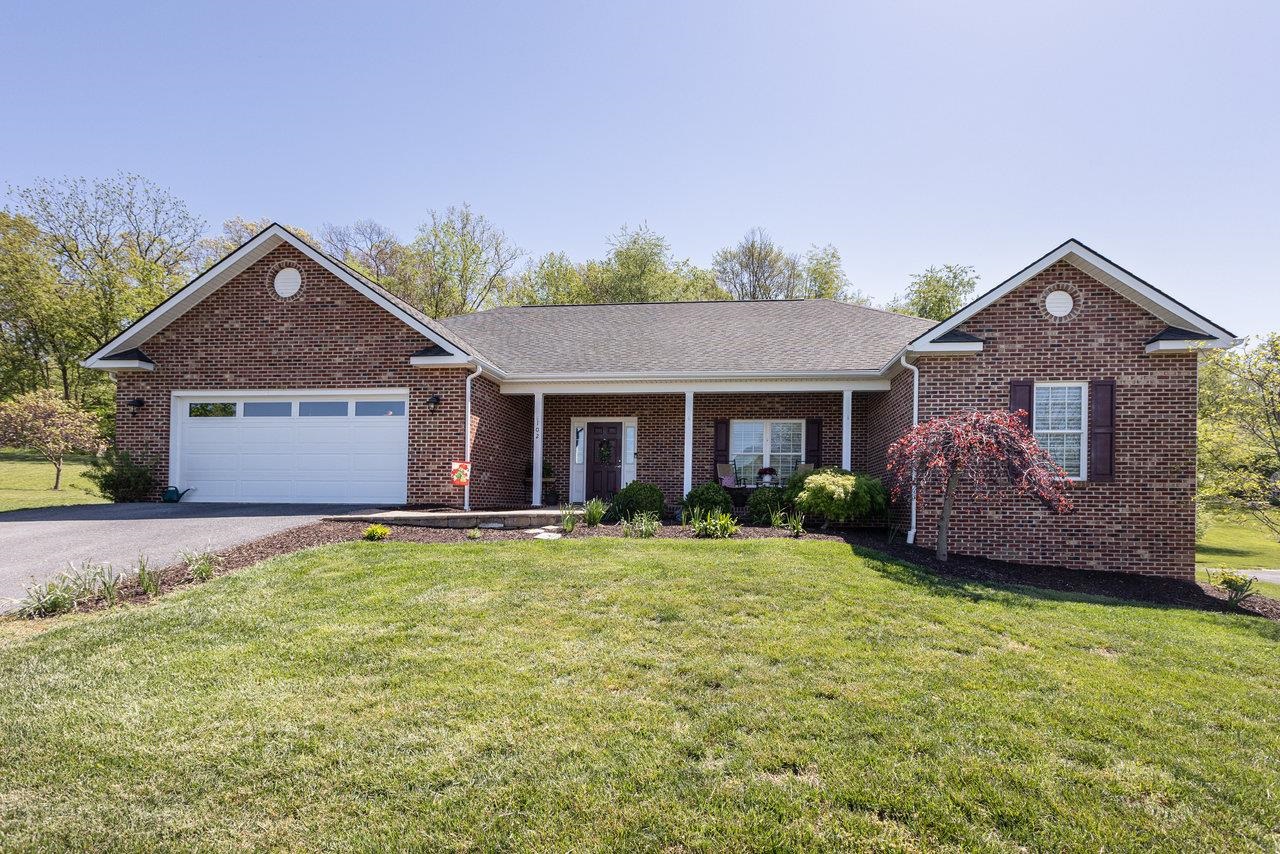 a front view of a house with a garden and yard