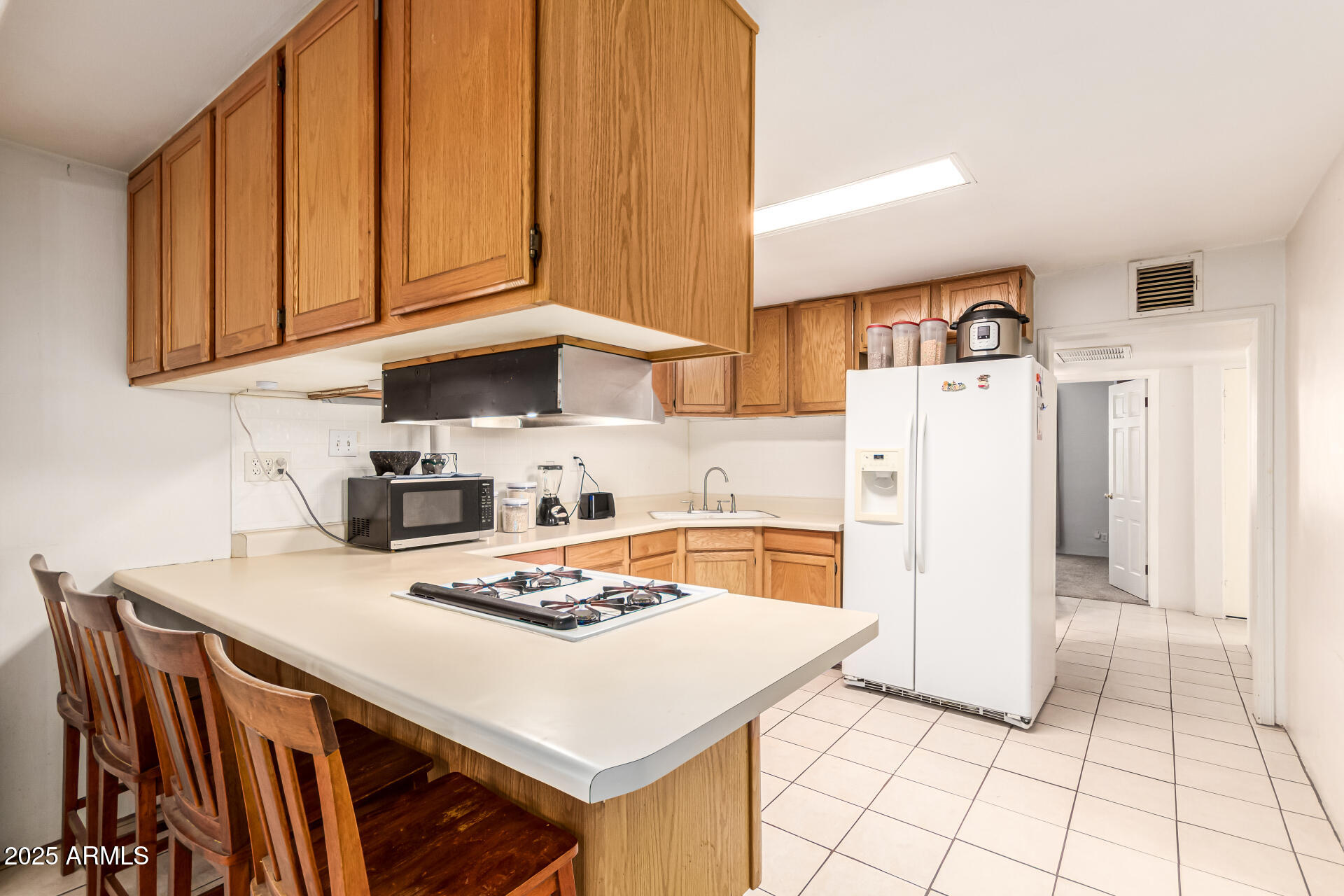 710 East Atlanta Avenue Phoenix, AZ 85040 - Photo 8 of 21 a kitchen with stainless steel appliances a table a stove a refrigerator and cabinets