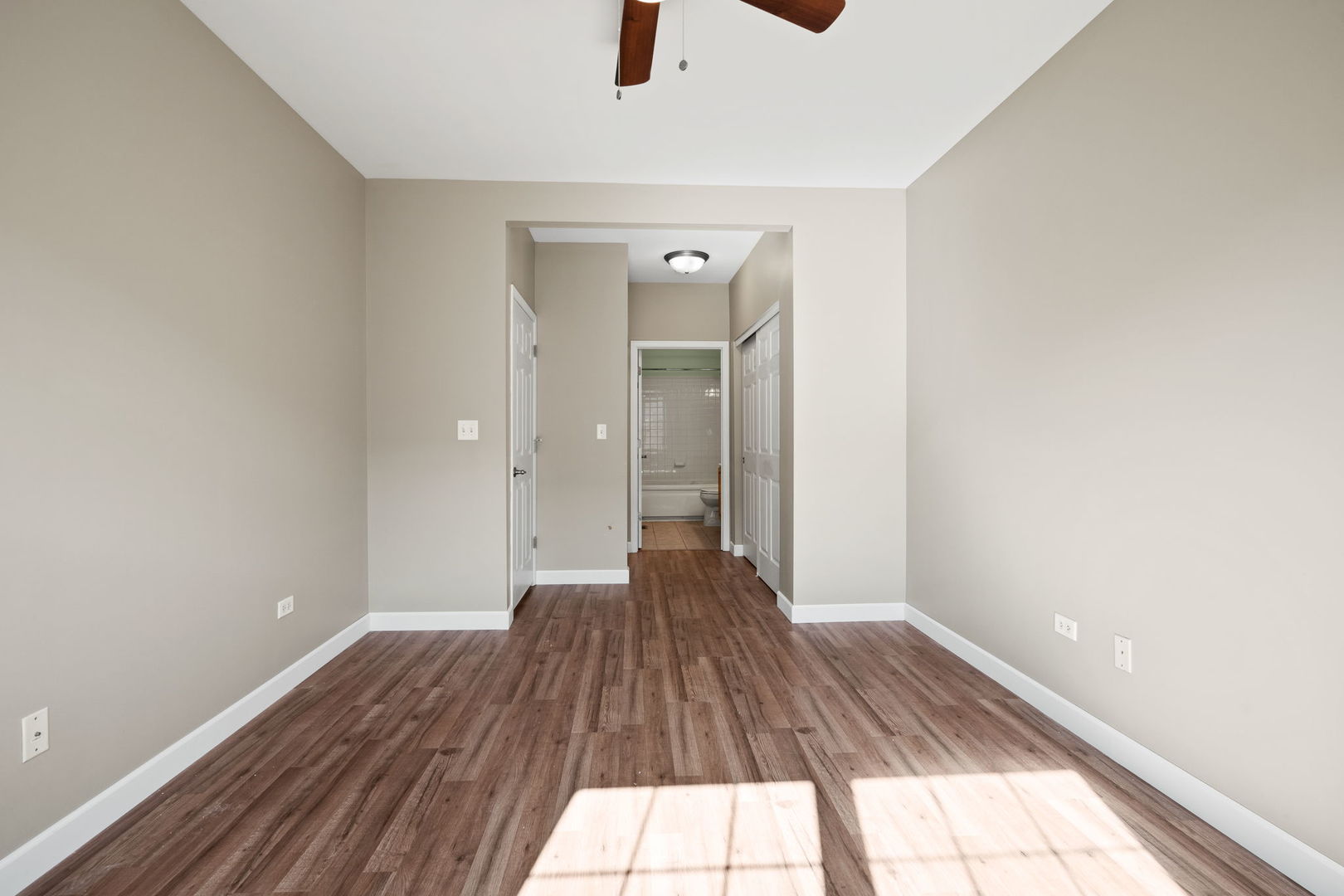 2568 Golf Ridge Circle, Unit 2568 Naperville, IL 60563 - Photo 11 of 18 a view of a big room with wooden floor a ceiling fan and windows