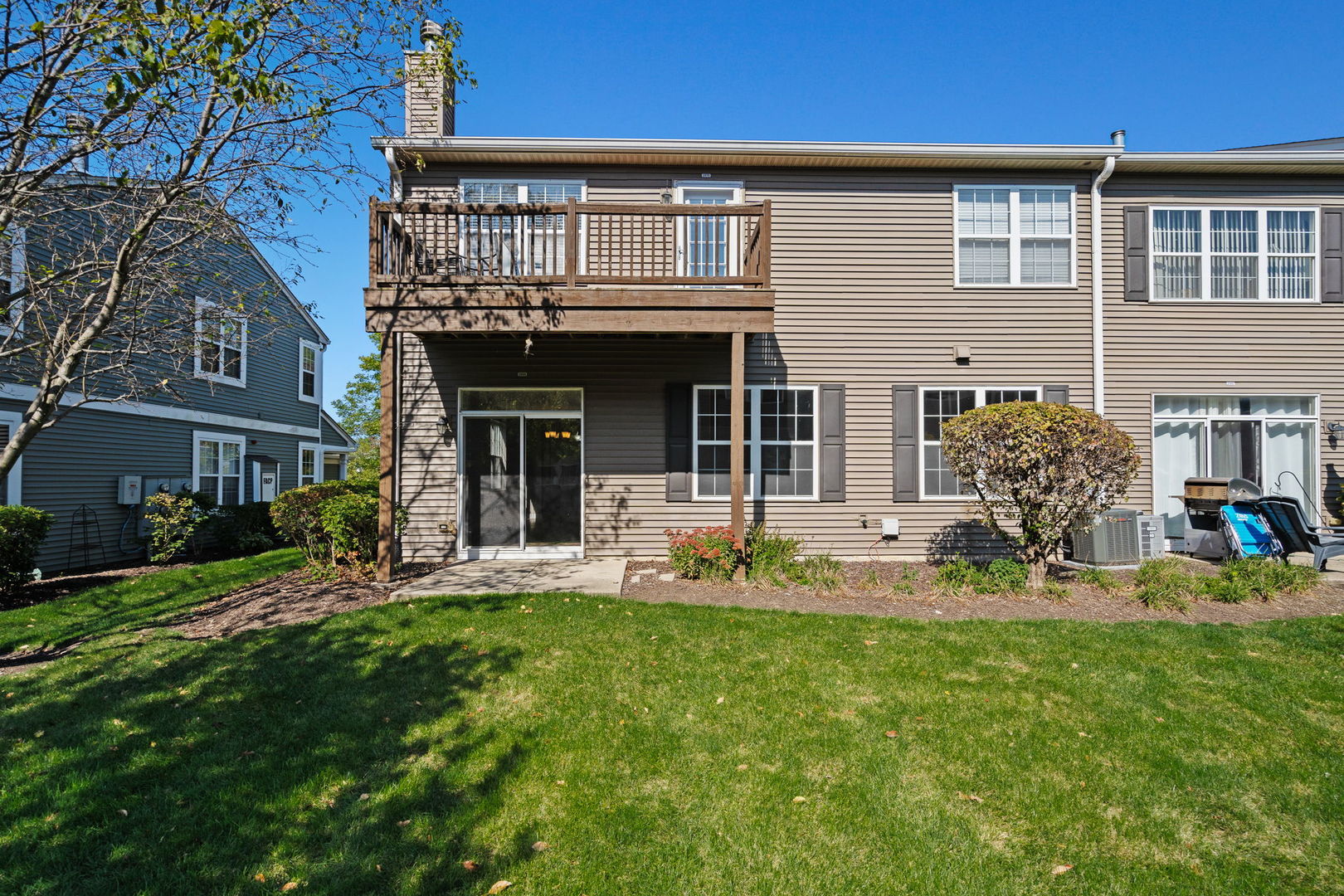 2568 Golf Ridge Circle, Unit 2568 Naperville, IL 60563 - Photo 17 of 18 a front view of a house with a garden and sitting area