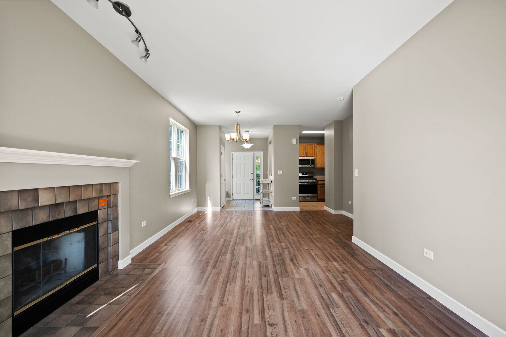 2568 Golf Ridge Circle, Unit 2568 Naperville, IL 60563 - Photo 3 of 18 a view of an empty room with wooden floor fireplace and a window