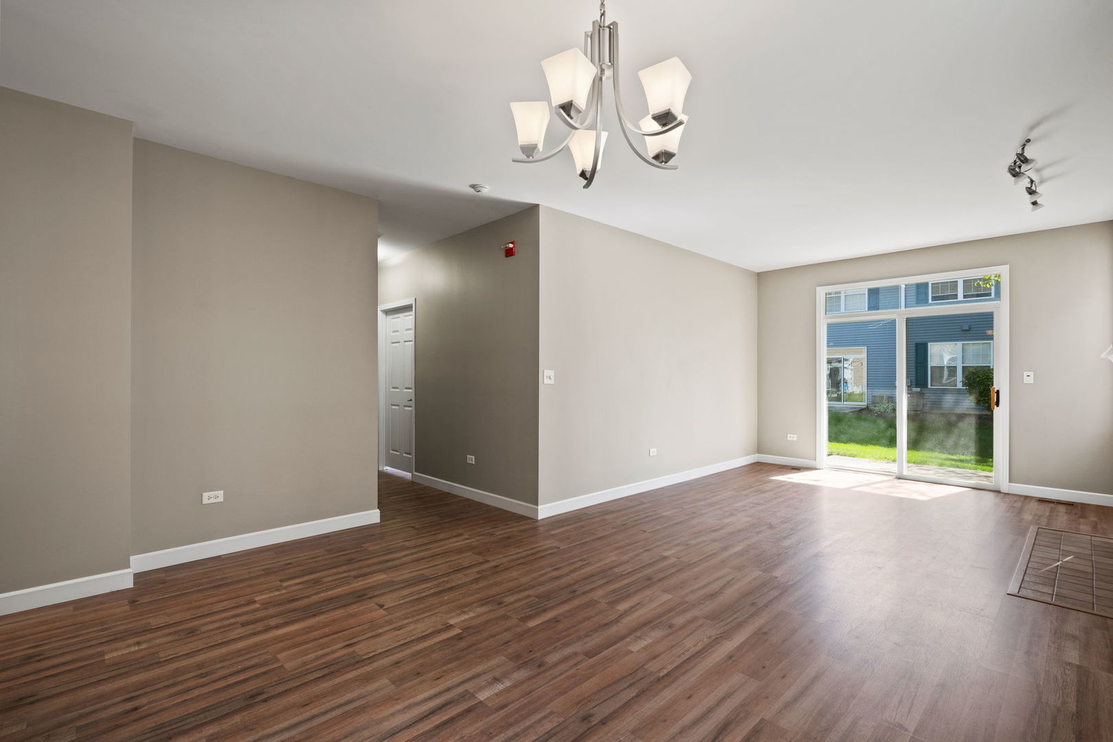 2568 Golf Ridge Circle, Unit 2568 Naperville, IL 60563 - Photo 5 of 18 a view of an empty room with wooden floor and windows