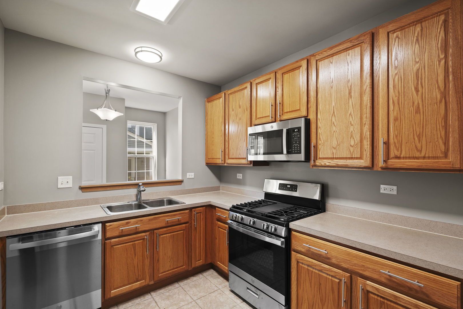 2568 Golf Ridge Circle, Unit 2568 Naperville, IL 60563 - Photo 7 of 18 a kitchen with stainless steel appliances granite countertop a stove a sink and a microwave