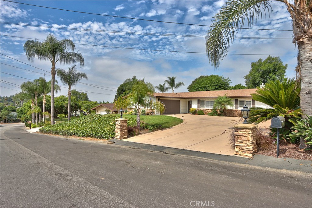 a front view of a house with a yard and potted plants