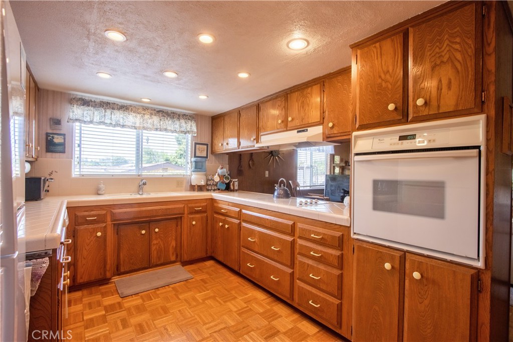335 Zada Lane Vista, CA 92084 - Photo 10 of 44 a kitchen with stainless steel appliances granite countertop wooden cabinets a stove a sink and a refrigerator
